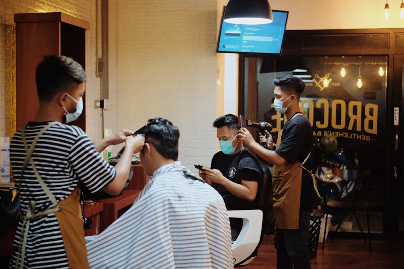 Barber Brocode sedang memotong rambut pelanggan